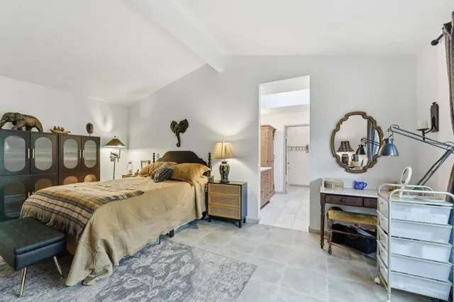 a bedroom with a bed a mirror and a table