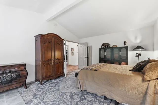 a bedroom with a bed and a refrigerator