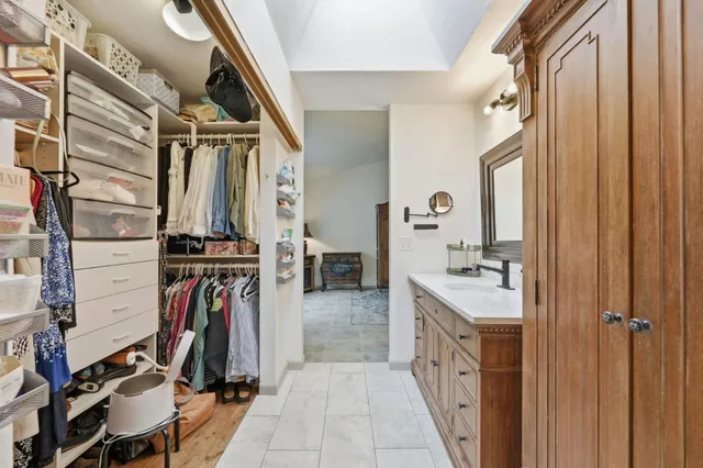 a view of walk in closet with clothes and shoes