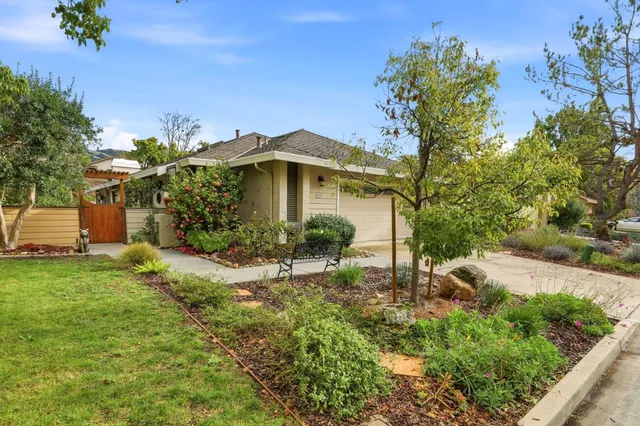 a view of a house with a yard and potted plants