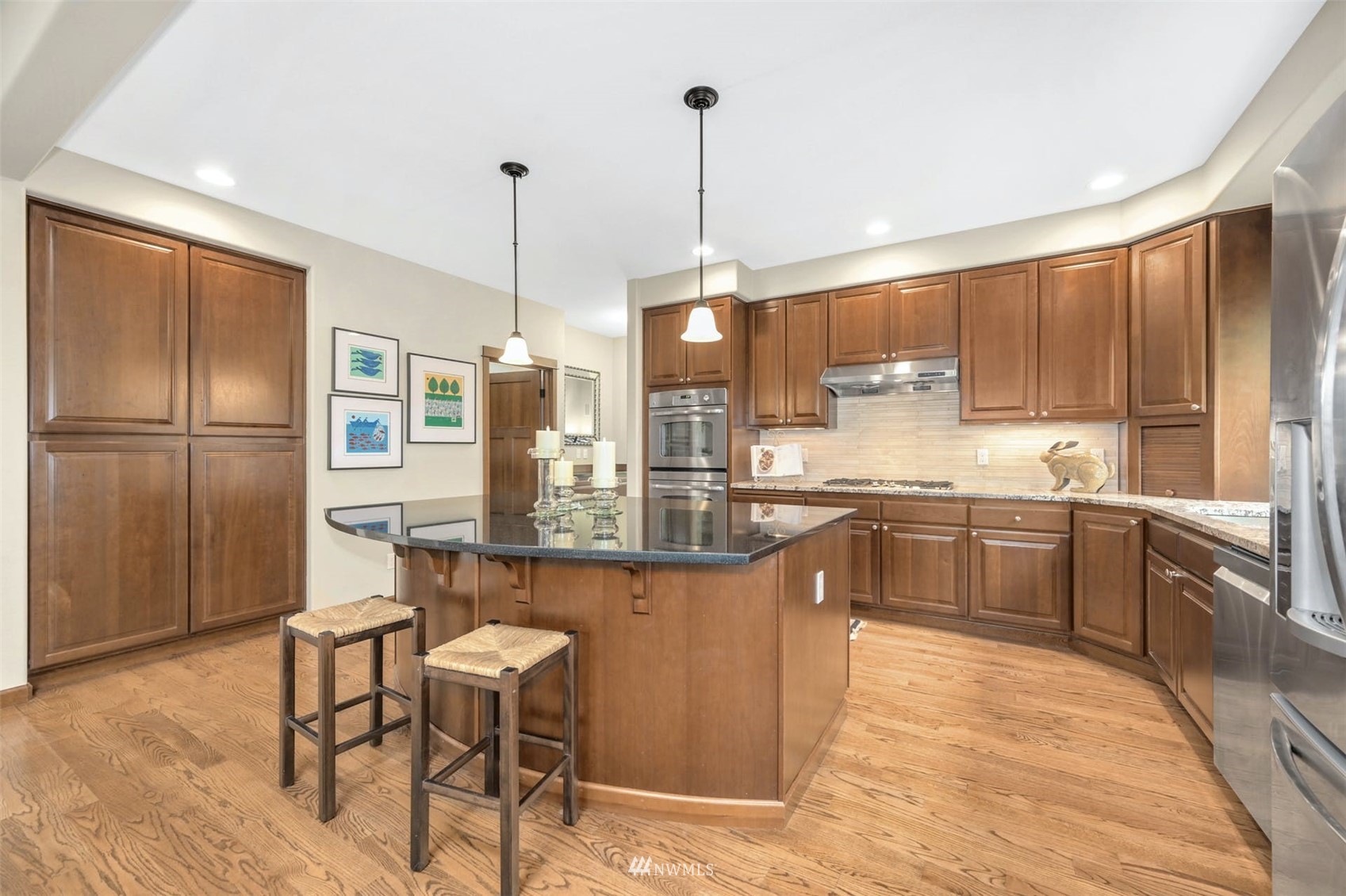 22722 16th Avenue West Bothell, WA 98021 - Photo 12 of 39 a kitchen with stainless steel appliances granite countertop a refrigerator a sink dishwasher a stove and a dining table with wooden floor
