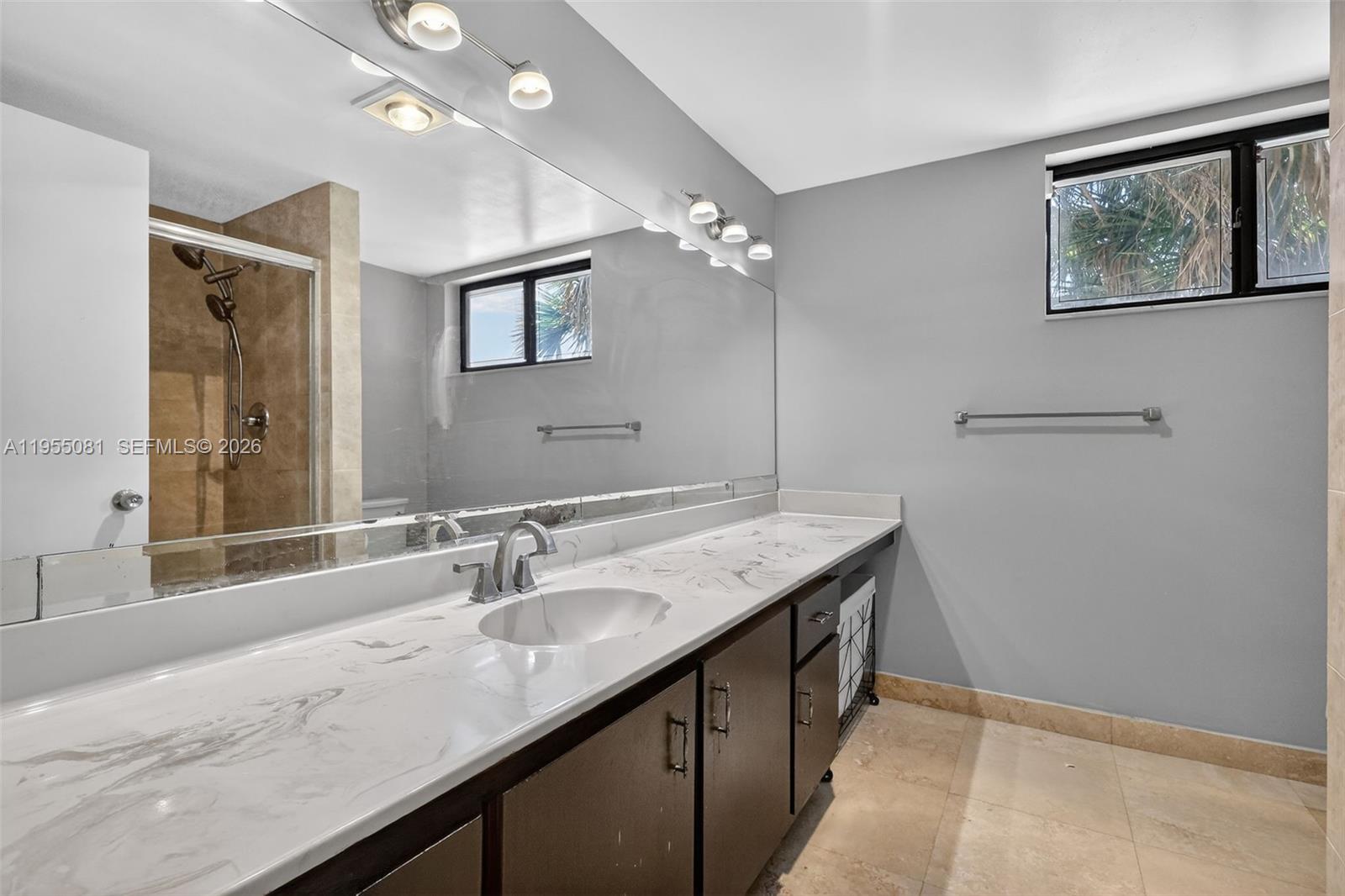 491 Ives Dairy Road, Unit 3065 Miami, FL 33179 - Photo 23 of 41 a bathroom with a granite countertop sink a large mirror and a shower