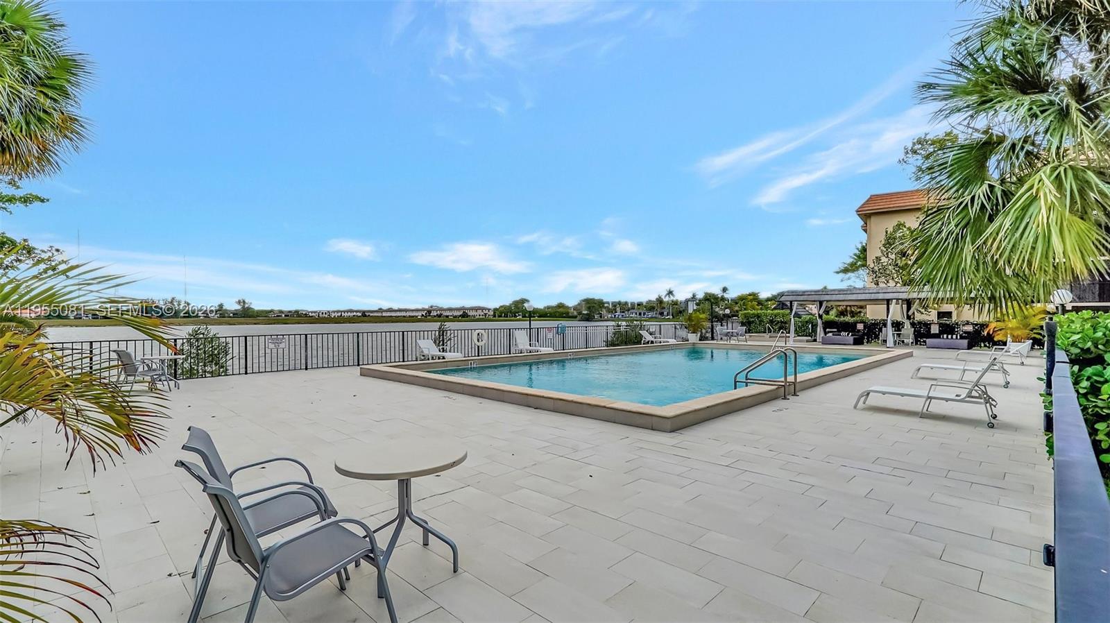 491 Ives Dairy Road, Unit 3065 Miami, FL 33179 - Photo 34 of 41 a view of a swimming pool with a lawn chairs under an umbrella