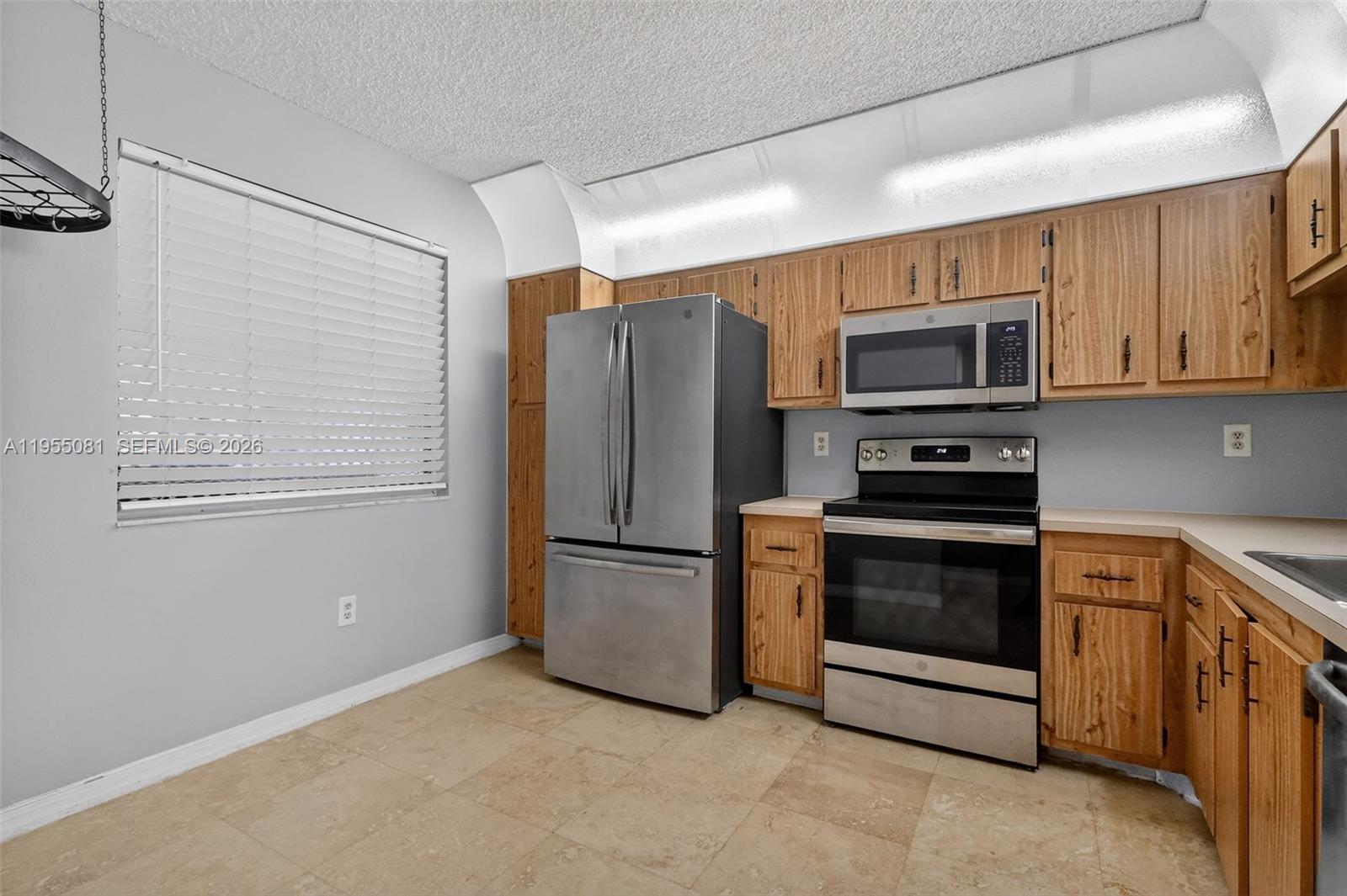 491 Ives Dairy Road, Unit 3065 Miami, FL 33179 - Photo 9 of 41 a kitchen with granite countertop a refrigerator and a stove top oven