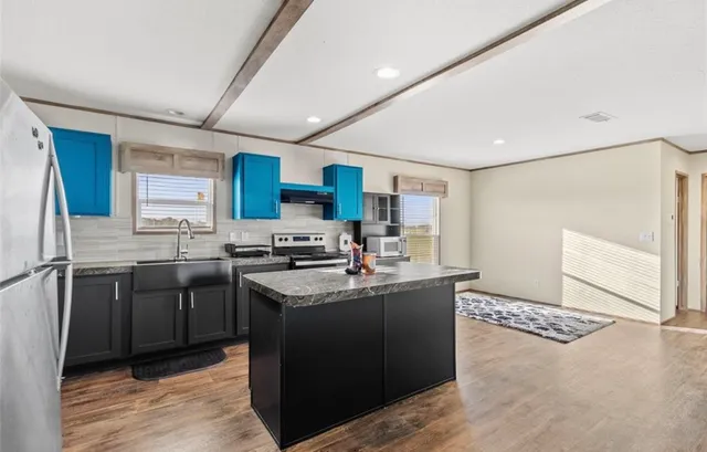 a kitchen with stainless steel appliances granite countertop a sink stove and refrigerator