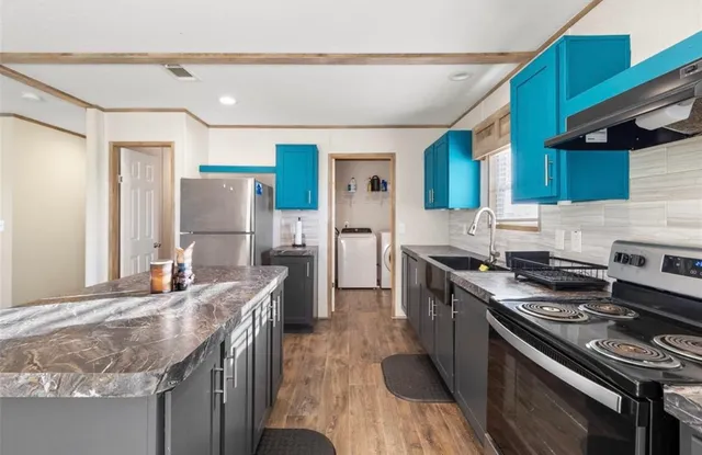 a kitchen with stainless steel appliances granite countertop a stove a sink dishwasher and a refrigerator