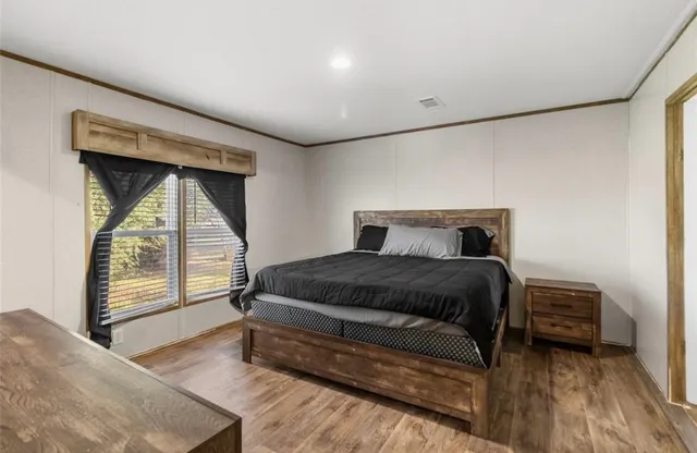 a bedroom with a bed and a large window