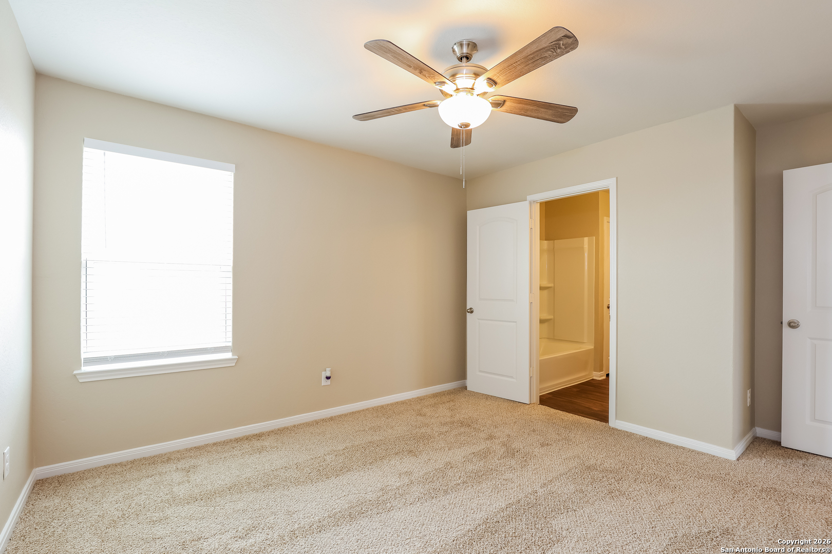 7213 Romaire San Antonio, TX 78252 - Photo 14 of 15 an empty room with a window and a chandelier fan