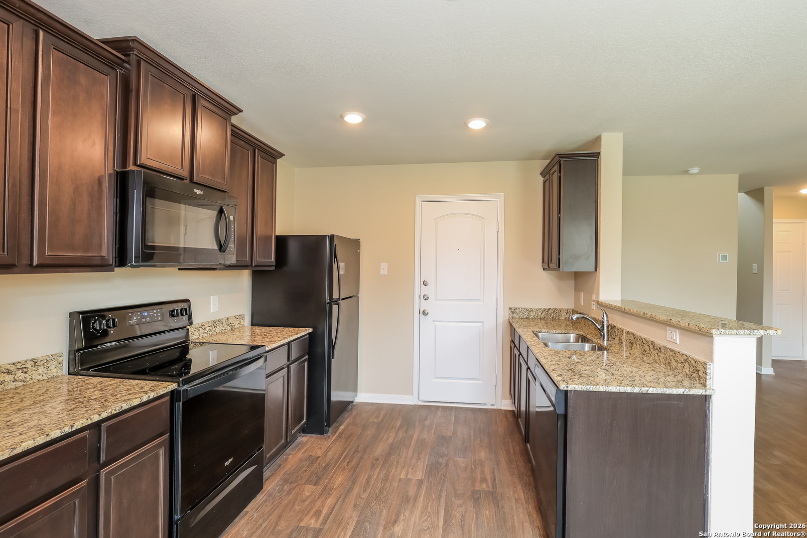 7213 Romaire San Antonio, TX 78252 - Photo 3 of 15 a kitchen with stainless steel appliances granite countertop a sink stove microwave and refrigerator