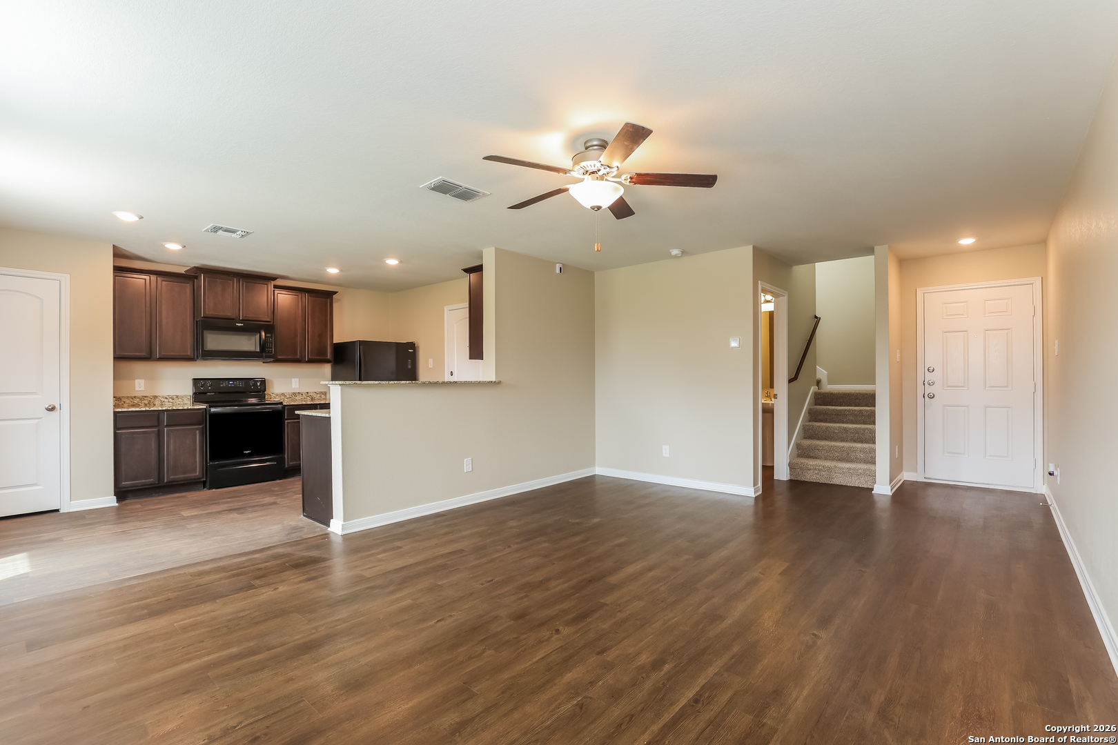 7213 Romaire San Antonio, TX 78252 - Photo 6 of 15 a view of an empty room with wooden floor and a kitchen