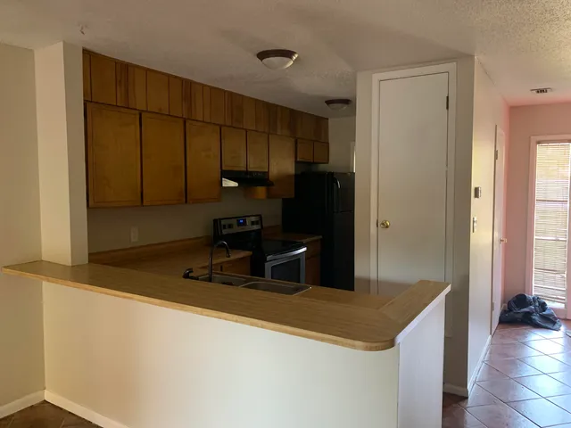 a kitchen with stainless steel appliances granite countertop a sink and a refrigerator
