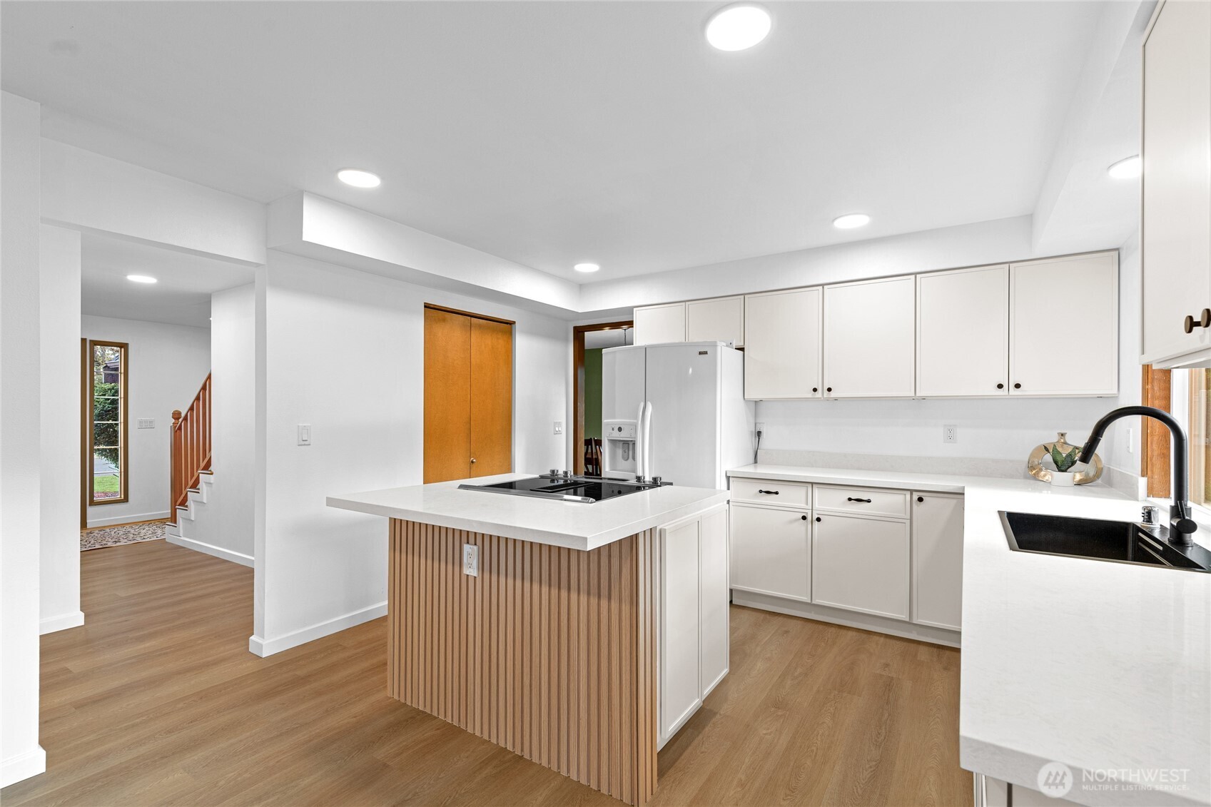 5824 111th Place Southwest Mukilteo, WA 98275 - Photo 7 of 38 a kitchen with stainless steel appliances granite countertop a stove top oven a sink a refrigerator and white cabinets with wooden floor