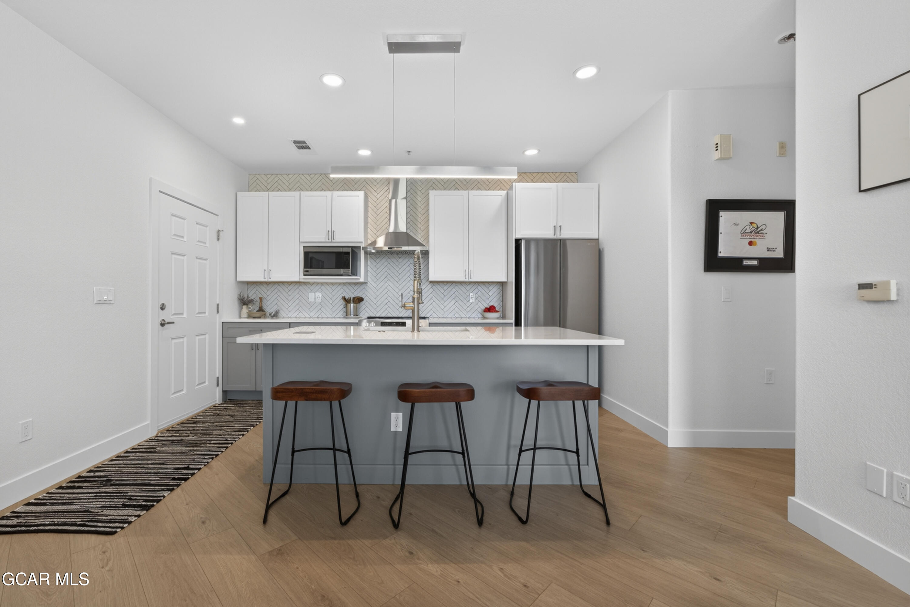 160 Village Road, Unit F207 Granby, CO 80446 - Photo 8 of 28 a kitchen with kitchen island white cabinets and stainless steel appliances