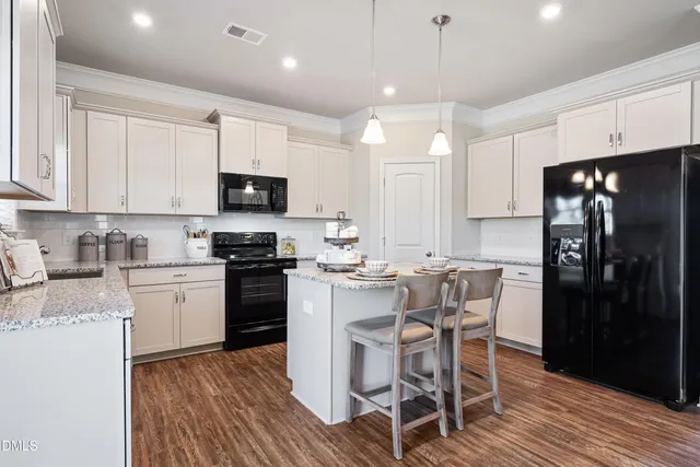 a kitchen with a table chairs refrigerator and microwave