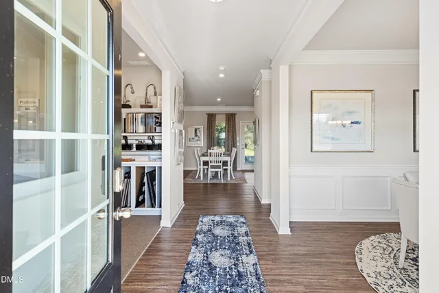 a view of a hallway with wooden floor and living room