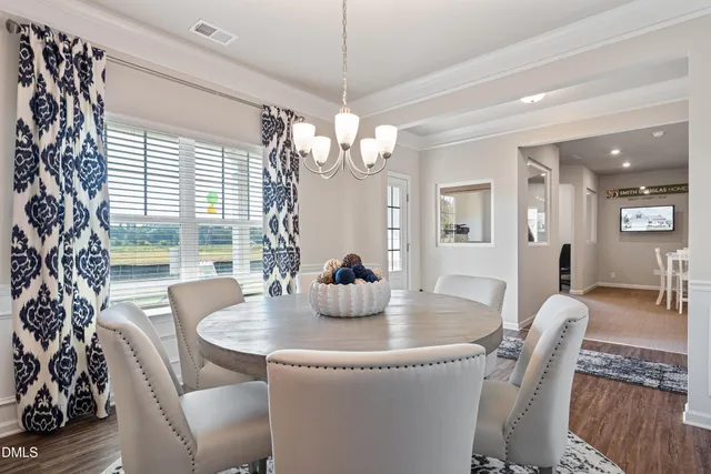 a dining room with furniture a chandelier and window