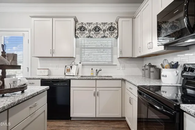 a kitchen with granite countertop white cabinets and white appliances