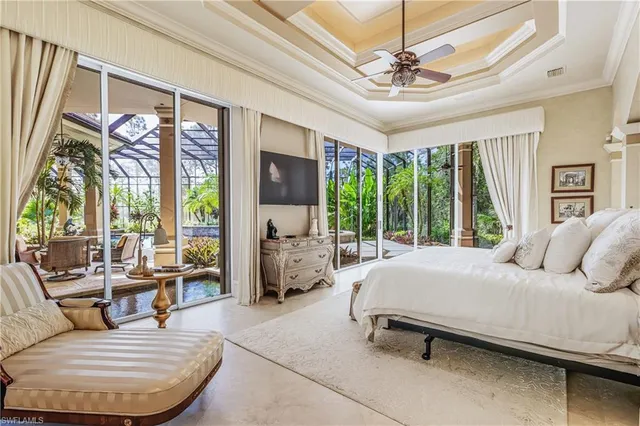 a bedroom with a bed a large window and couch