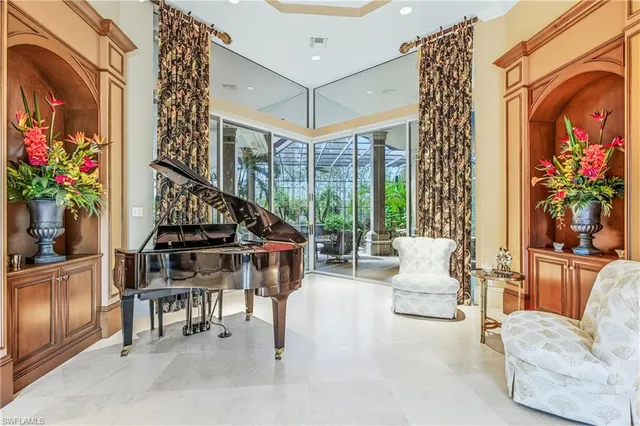 a living room with furniture a piano a potted plant and a large window