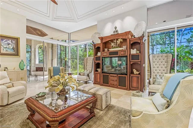 a living room with furniture a flat screen tv and a large window
