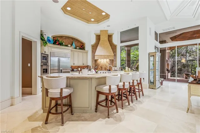 a dining hall with stainless steel appliances a dining table and chairs with floor to ceiling window