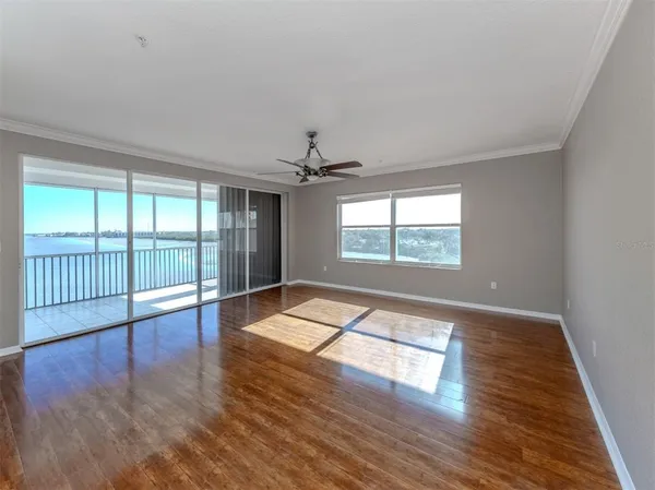 a living room with a floor to ceiling window and wooden floor