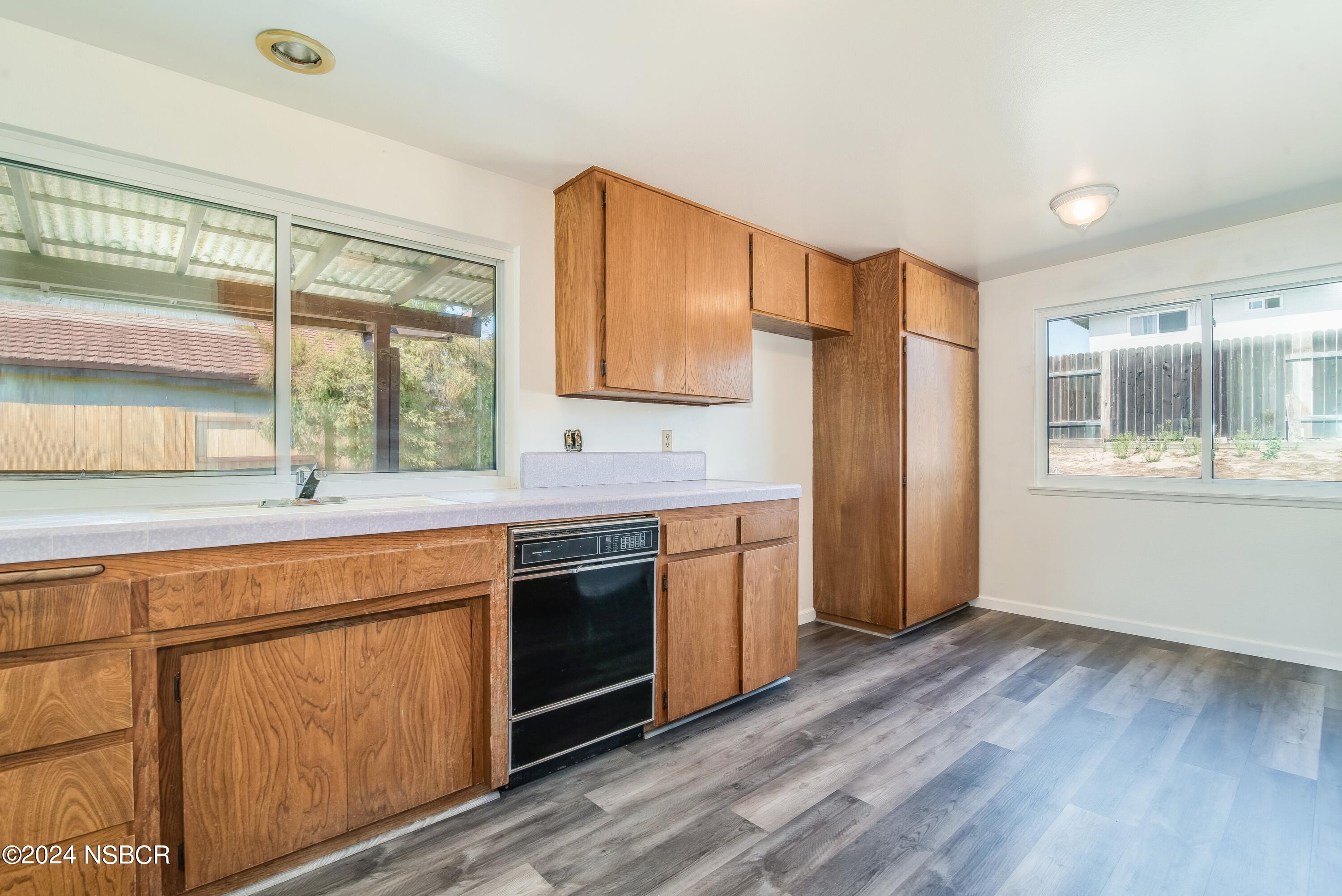 4149 Constellation Road Lompoc, CA 93436 - Photo 6 of 31 a kitchen with stainless steel appliances granite countertop a refrigerator a sink dishwasher a stove with wooden cabinets and floors