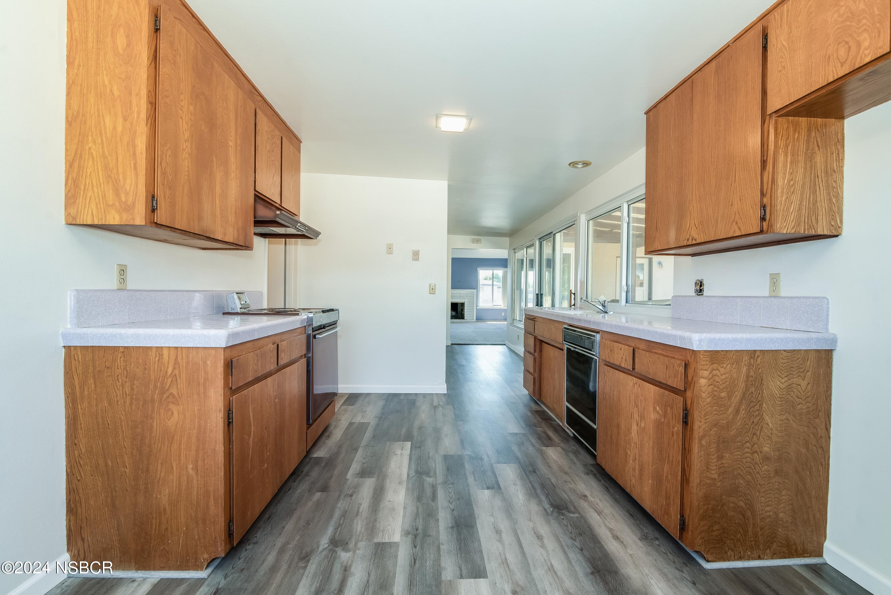 4149 Constellation Road Lompoc, CA 93436 - Photo 7 of 31 a kitchen with stainless steel appliances granite countertop wooden cabinets a sink and dishwasher a stove with wooden floor