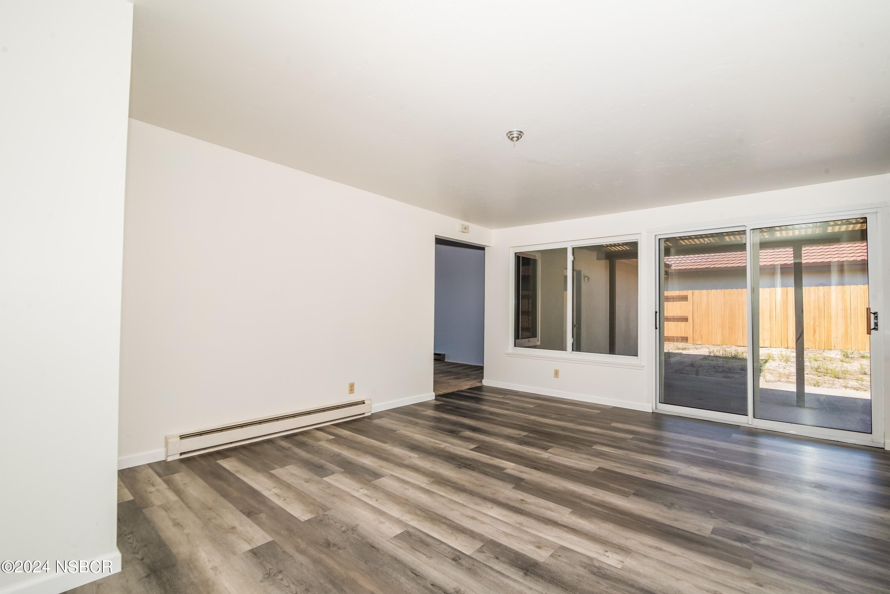 4149 Constellation Road Lompoc, CA 93436 - Photo 10 of 31 a view of an empty room with wooden floor and a window