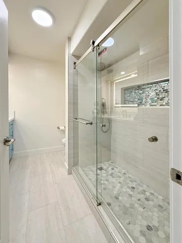 a bathroom with a shower and a glass door