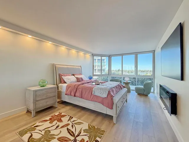 a spacious bedroom with a bed and a chandelier
