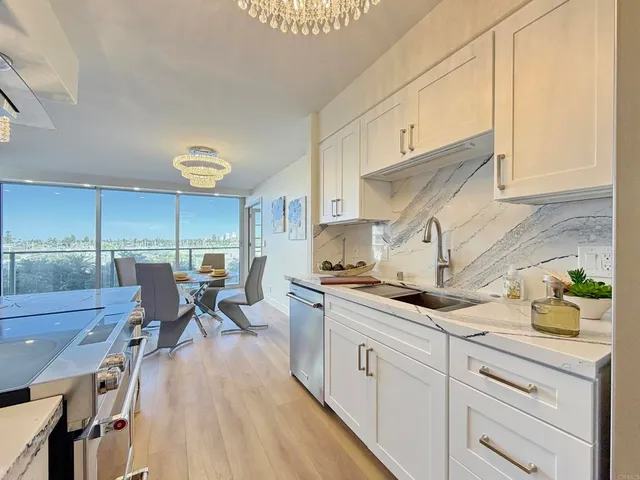 a kitchen with a sink a stove cabinets and wooden floor