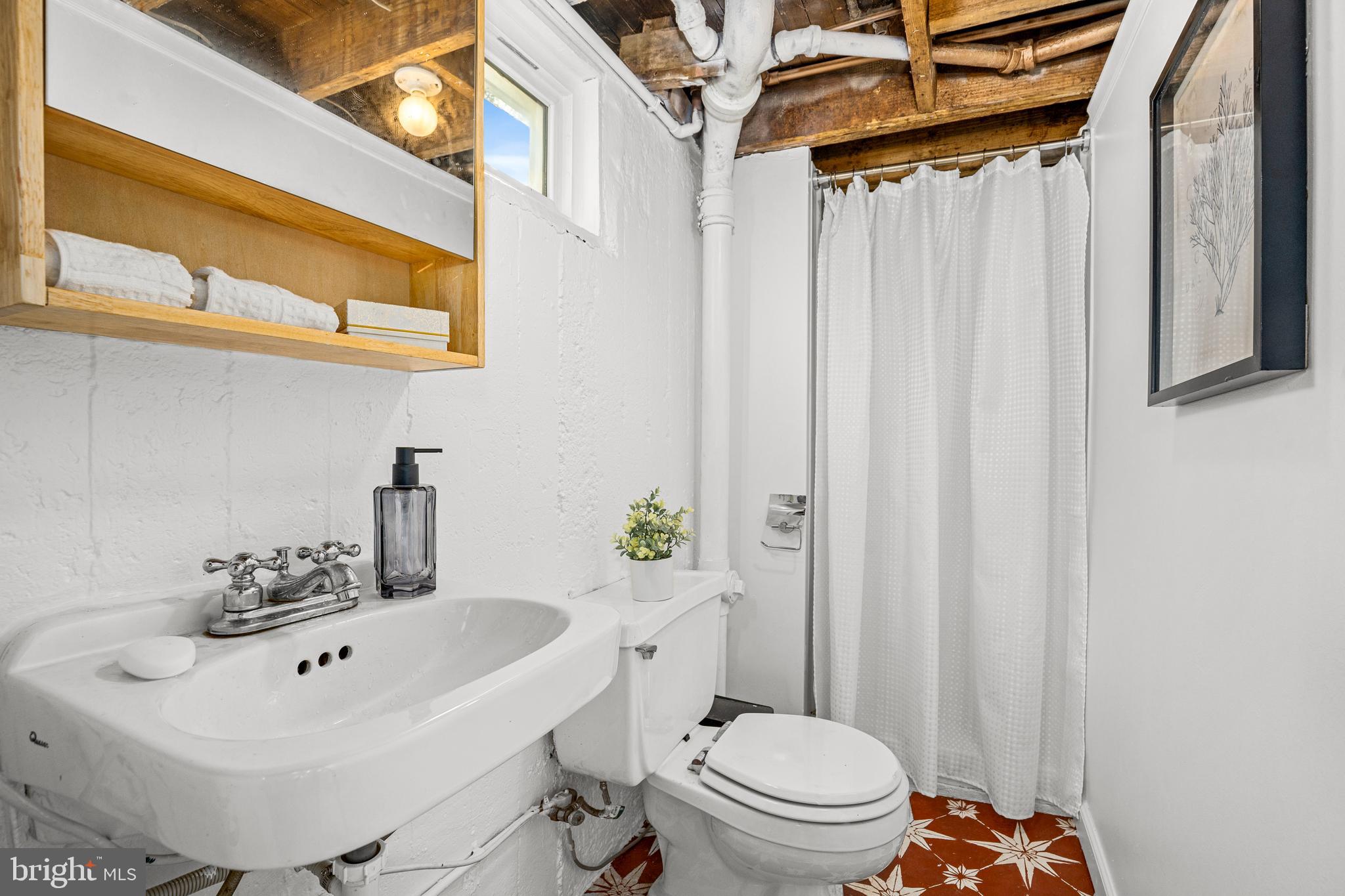 1327 Irving Street Northeast Washington, DC 20017 - Photo 32 of 39 a bathroom with a sink a toilet and shower curtain