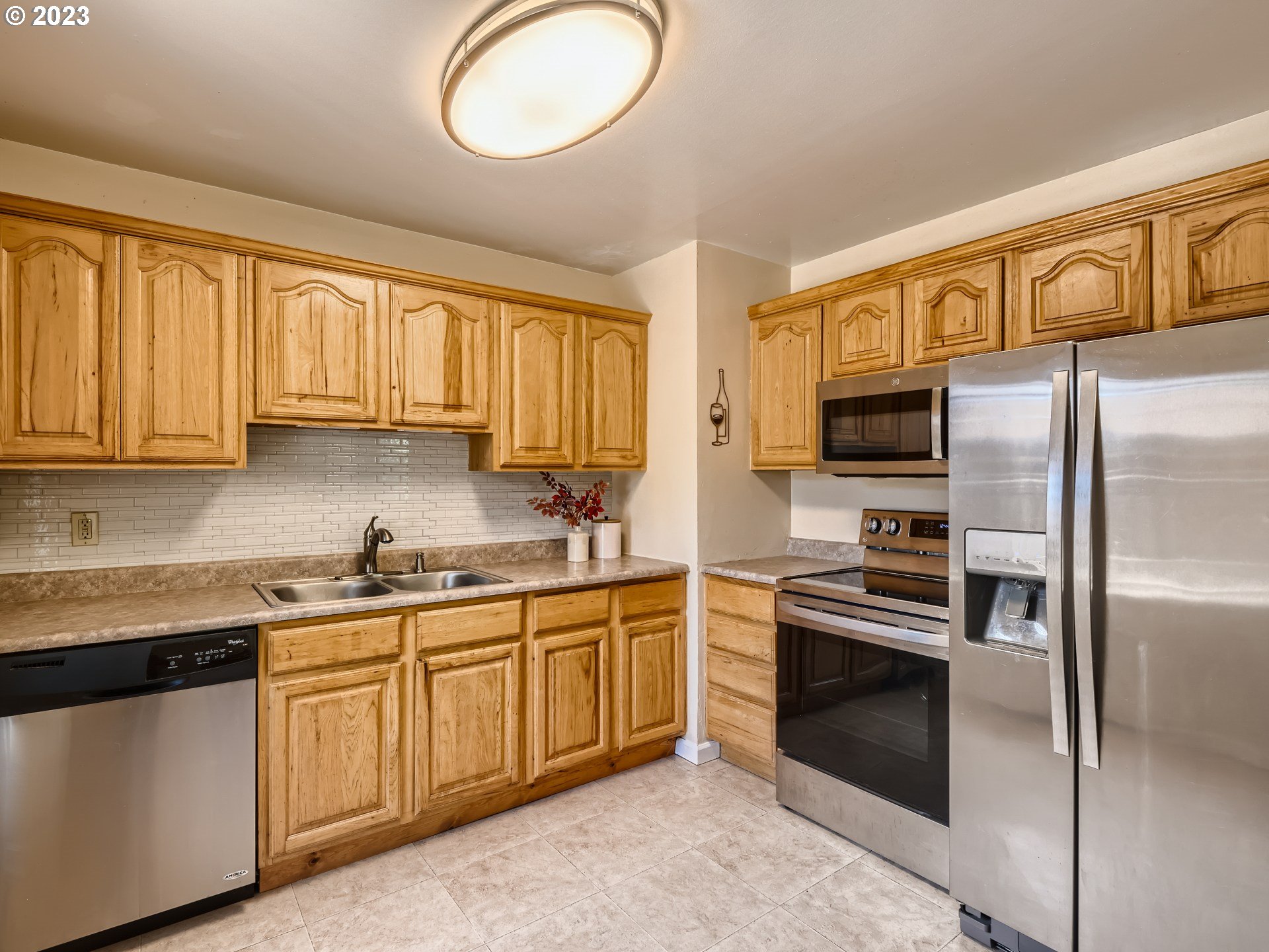 2546 Southeast 176th Place Portland, OR 97236 - Photo 9 of 24 a kitchen with stainless steel appliances granite countertop a stove a sink dishwasher a refrigerator and cabinets with wooden floor
