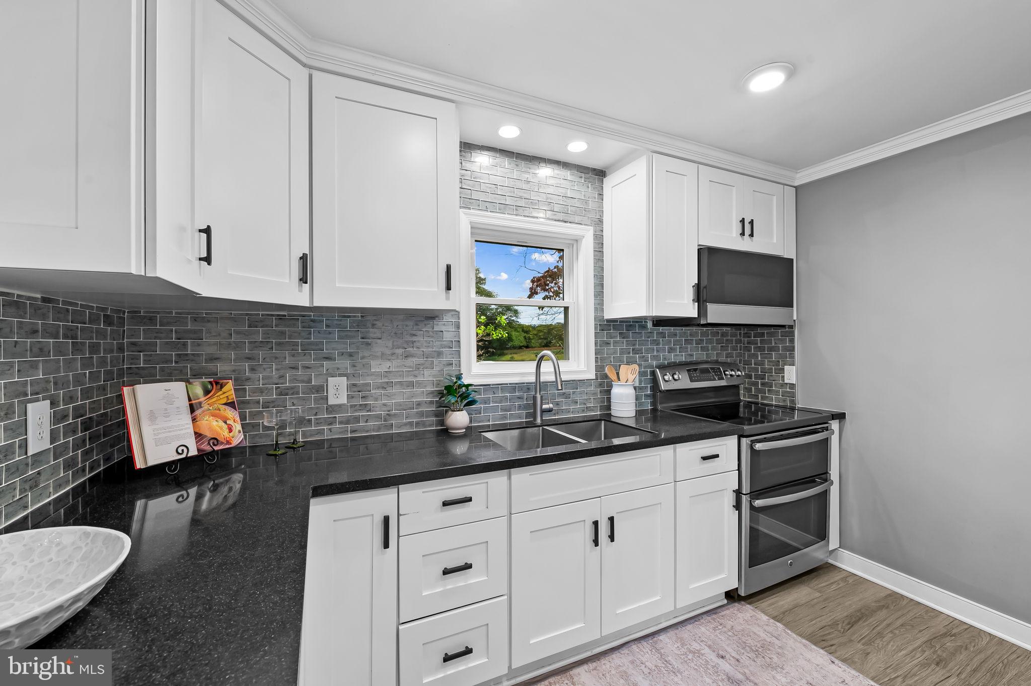 3332 Dublin Road Darlington, MD 21034 - Photo 17 of 39 a kitchen with stainless steel appliances white cabinets a stove a sink and a microwave