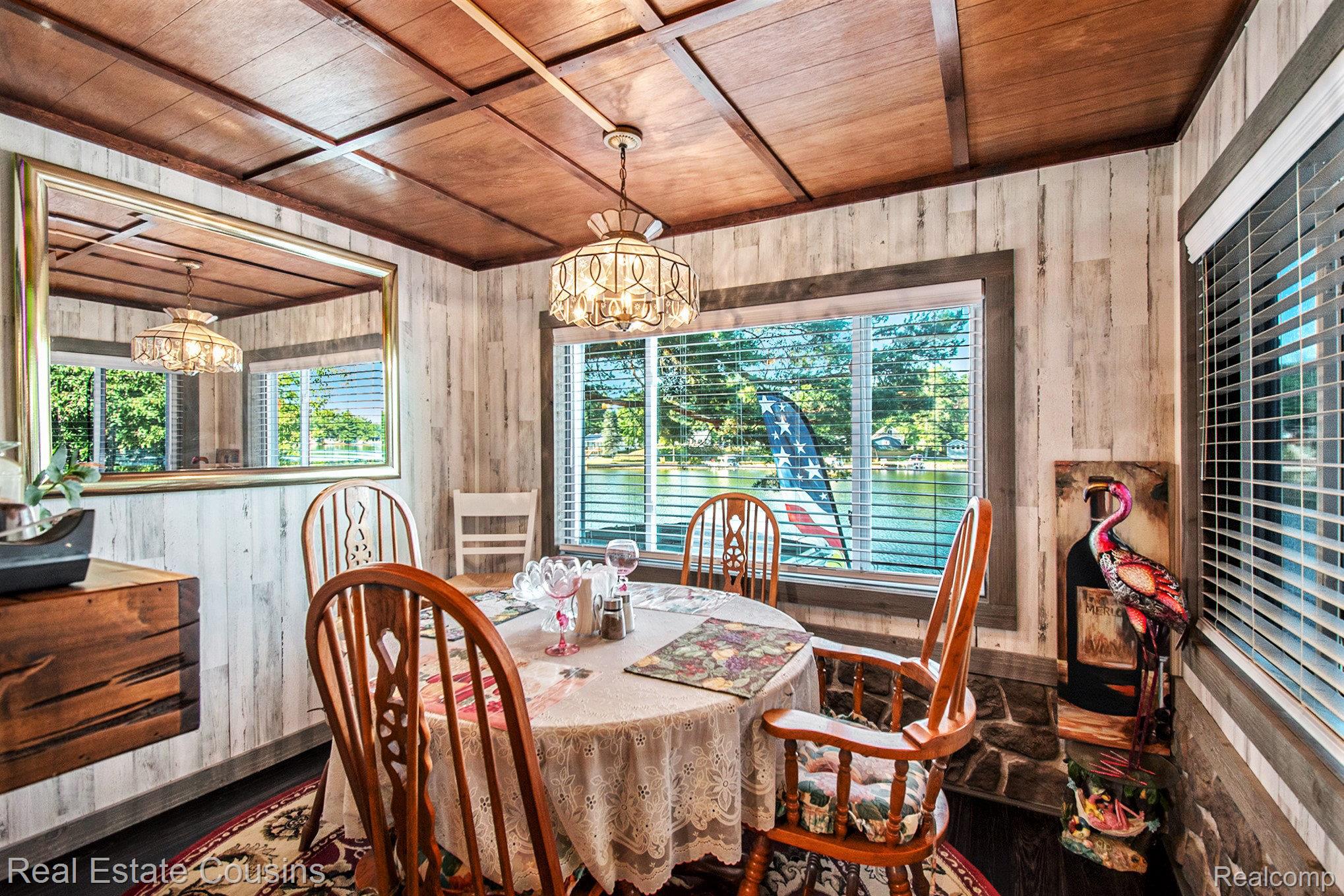 1734 Forest Road Harrison, MI 48625 - Photo 7 of 31 Dining room featuring a chandelier, wood ceiling, and wooden walls