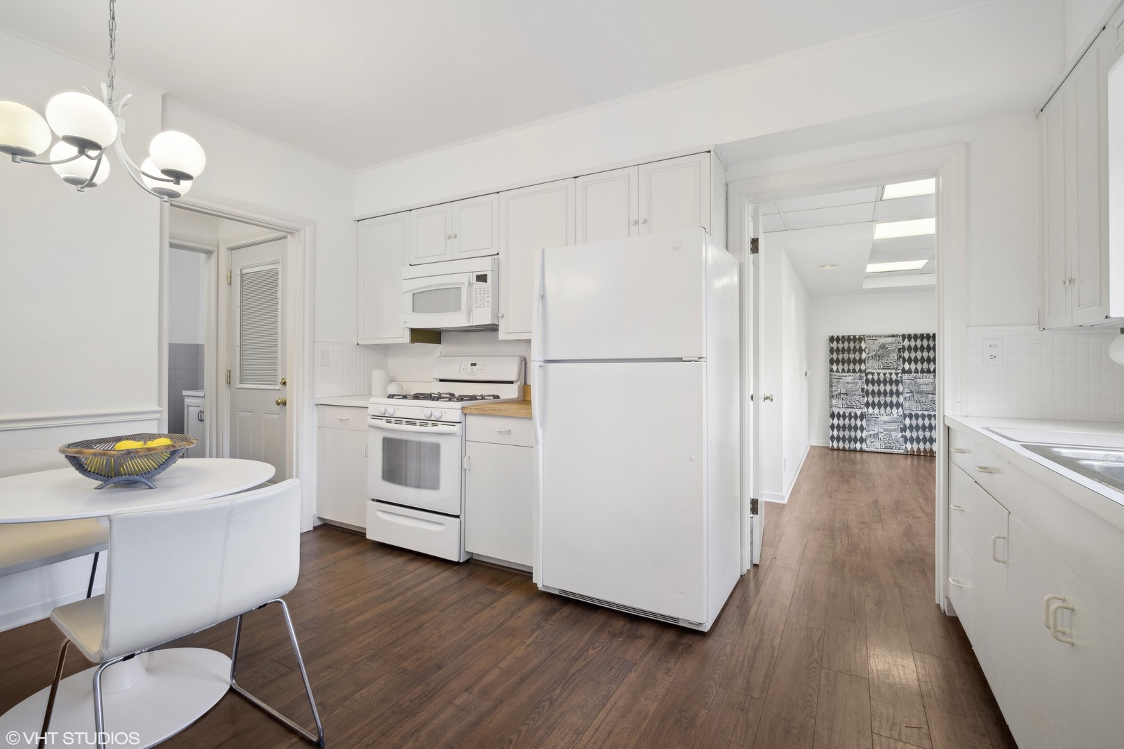 715 Wagner Road Glenview, IL 60025 - Photo 6 of 21 a kitchen with stainless steel appliances a stove a refrigerator and a dining table with wooden floor