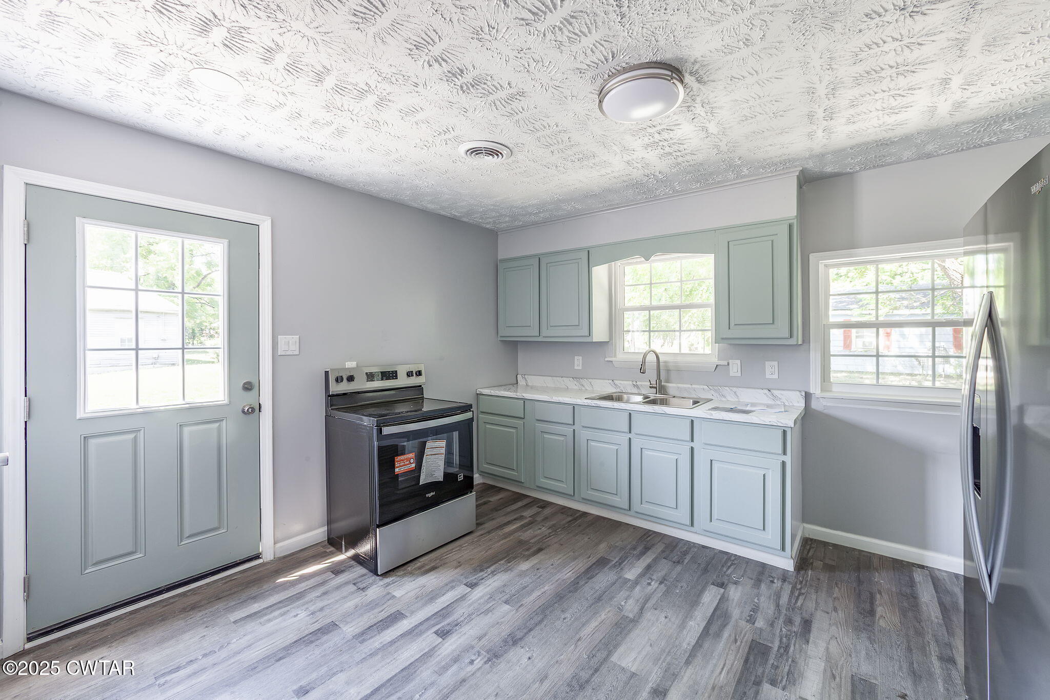 115 Neff Street Jackson, TN 38301 - Photo 11 of 23 a kitchen with stainless steel appliances granite countertop a stove a sink dishwasher and a refrigerator with wooden floors