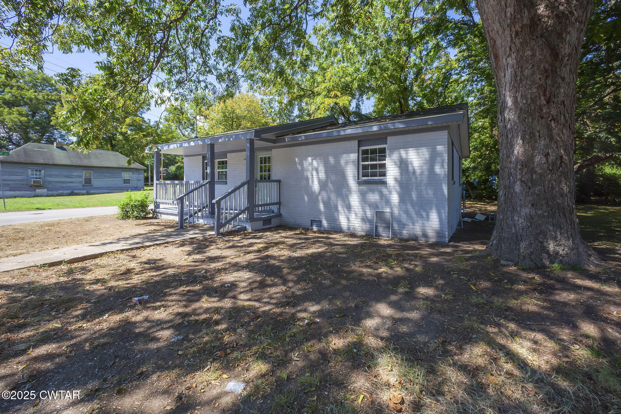 115 Neff Street Jackson, TN 38301 - Photo 3 of 23 a view of a barn house next to a yard with wooden fence and a large tree
