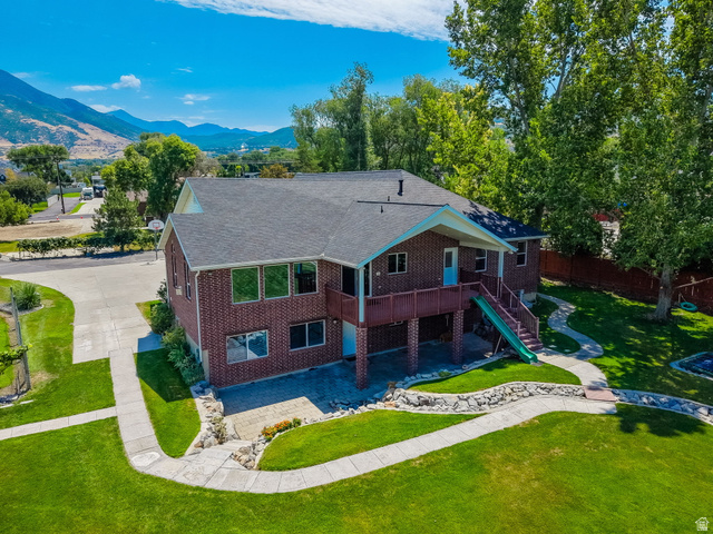 13658 South Fort Street Draper, UT 84020 - Photo 52 of 87 Brick exterior residence featuring a dark shingle roof, a two-story deck, and multiple large windows