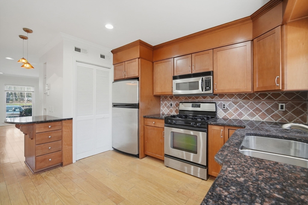 1155 Dickinson Street, Unit 1155 Springfield, MA 01108 - Photo 4 of 29 a kitchen with stainless steel appliances granite countertop a stove a sink and a refrigerator