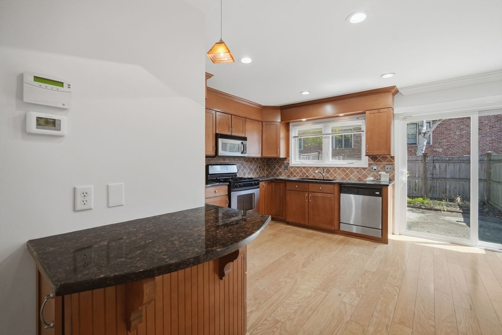1155 Dickinson Street, Unit 1155 Springfield, MA 01108 - Photo 5 of 29 a kitchen with granite countertop a stove a sink and a refrigerator