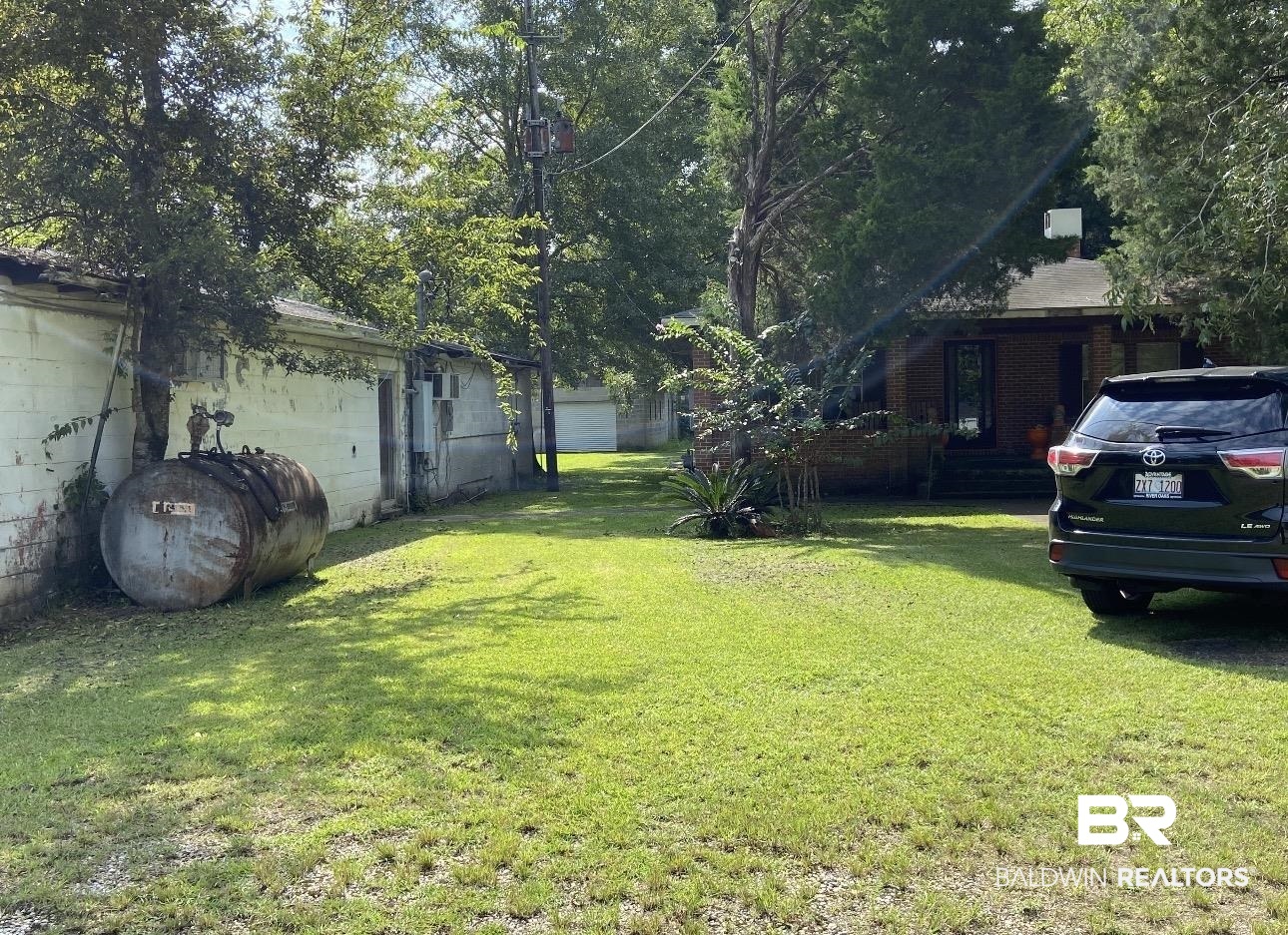 19380 Shepard Lake Road East Mount Vernon, AL 36560 - Photo 2 of 3 Expansive grass lawn featuring a brick-clad residence and an outbuilding with a metal fuel tank