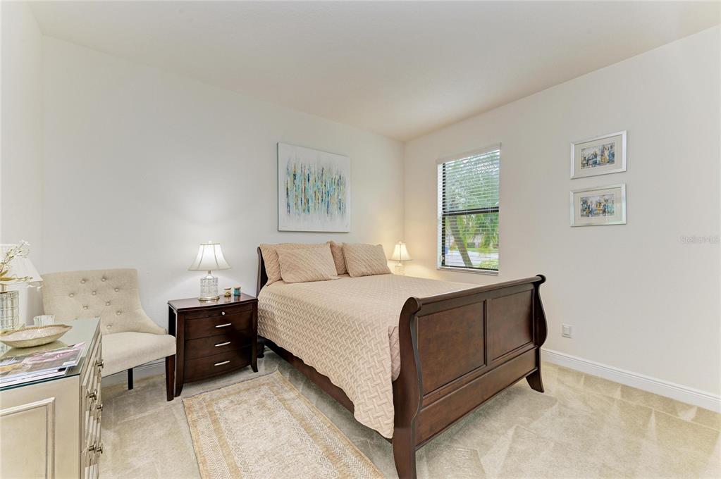 302 Cockle Shell Loop Apollo Beach, FL 33572 - Photo 38 of 75 a spacious bedroom with a bed and a table in it