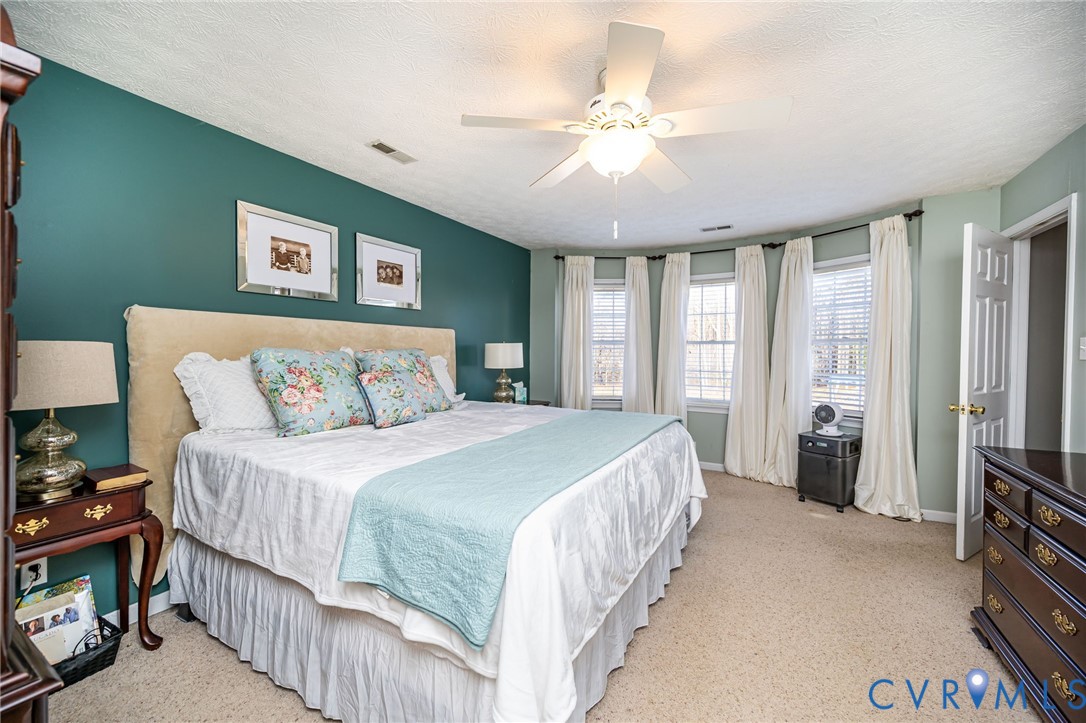 2423 Brookforest Road Midlothian, VA 23112 - Photo 24 of 40 a bedroom with a large bed and a chandelier