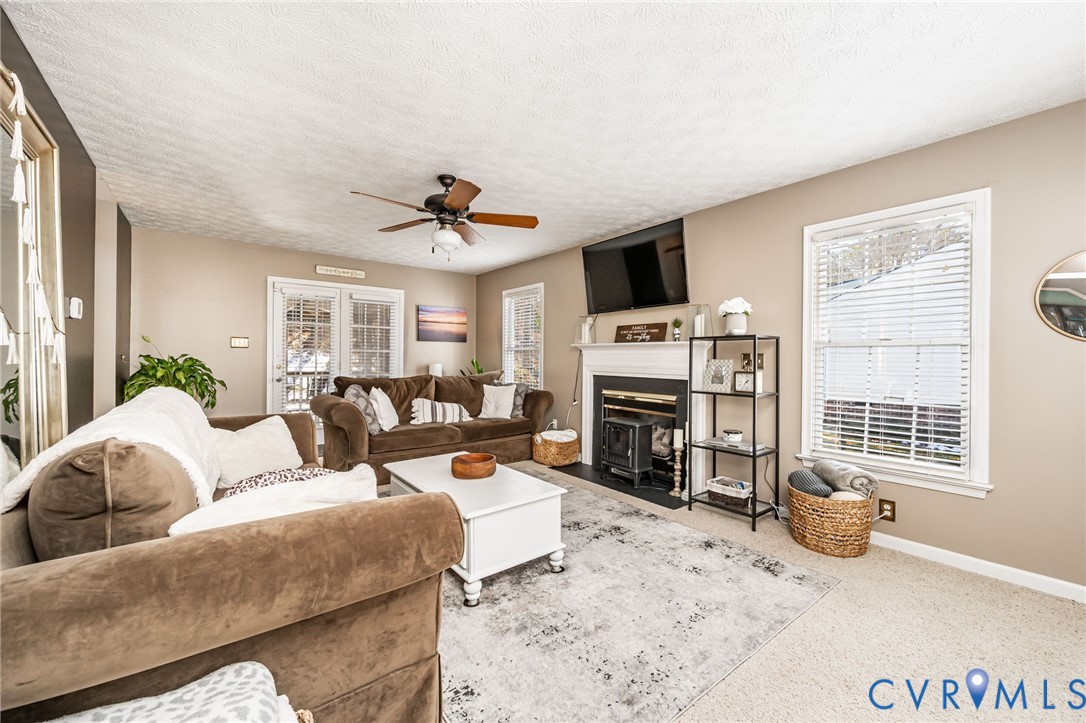 2423 Brookforest Road Midlothian, VA 23112 - Photo 9 of 40 a living room with furniture a flat screen tv and a fireplace