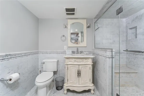 a bathroom with a granite countertop toilet sink and mirror