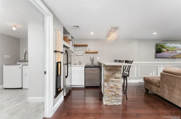 a living room with furniture and a refrigerator