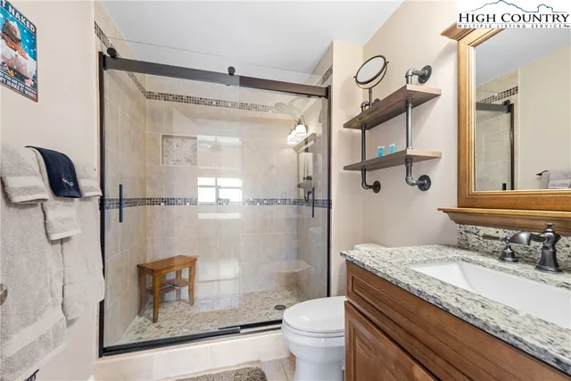 a bathroom with a granite countertop sink toilet and shower
