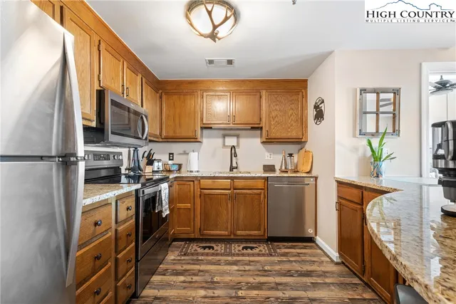 a kitchen with stainless steel appliances granite countertop a stove a sink and a refrigerator